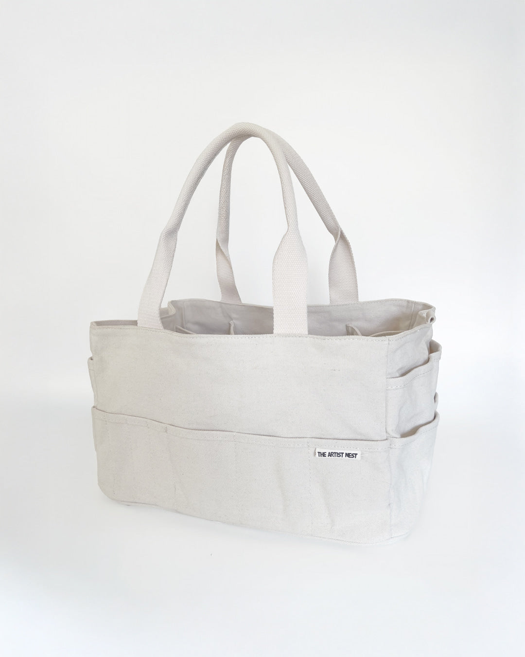 Drift white Artist Bag shown in a diagonal angle, canvas art supply bag with 18 exterior pockets and nine tall interior pockets, designed for creatives and makers in Australia.