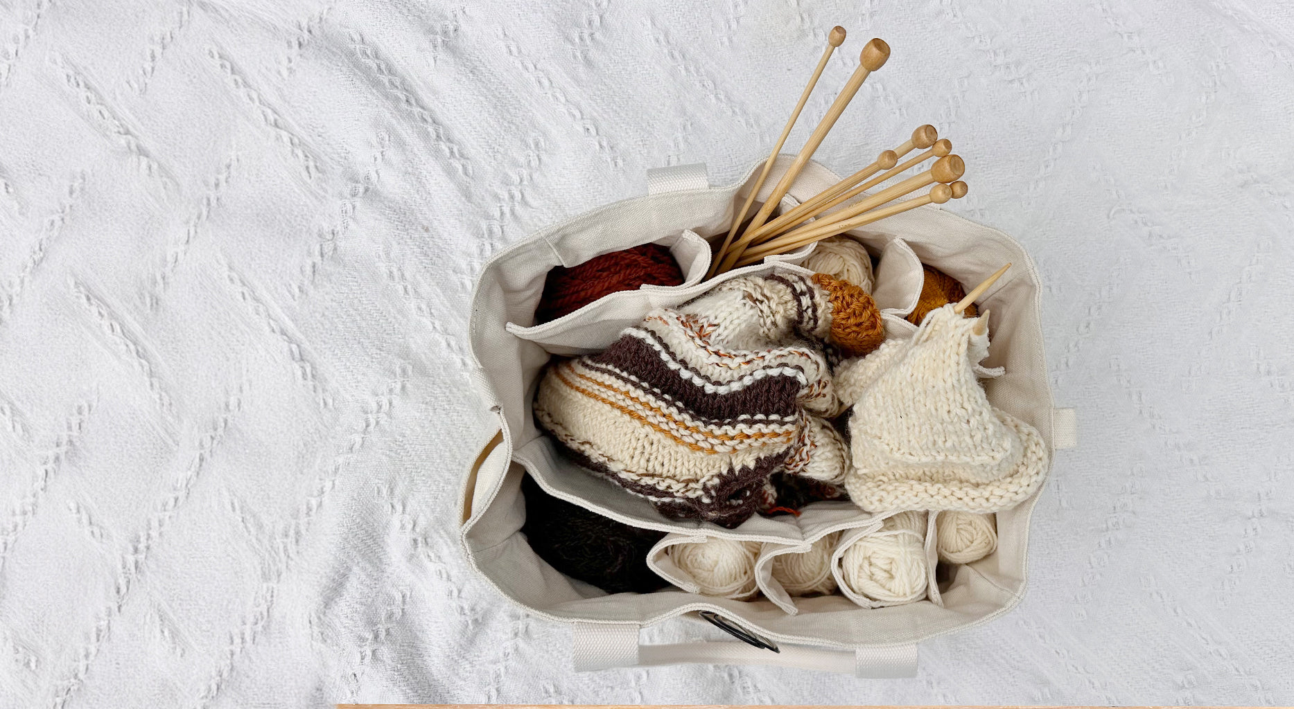 White Drift artist bag used by knitters and crocheters, with yarn, needles, and craft supplies neatly organised in multiple pockets.